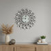 Decorative wall clock on a gray wall with a wooden cabinet below featuring decorative items.