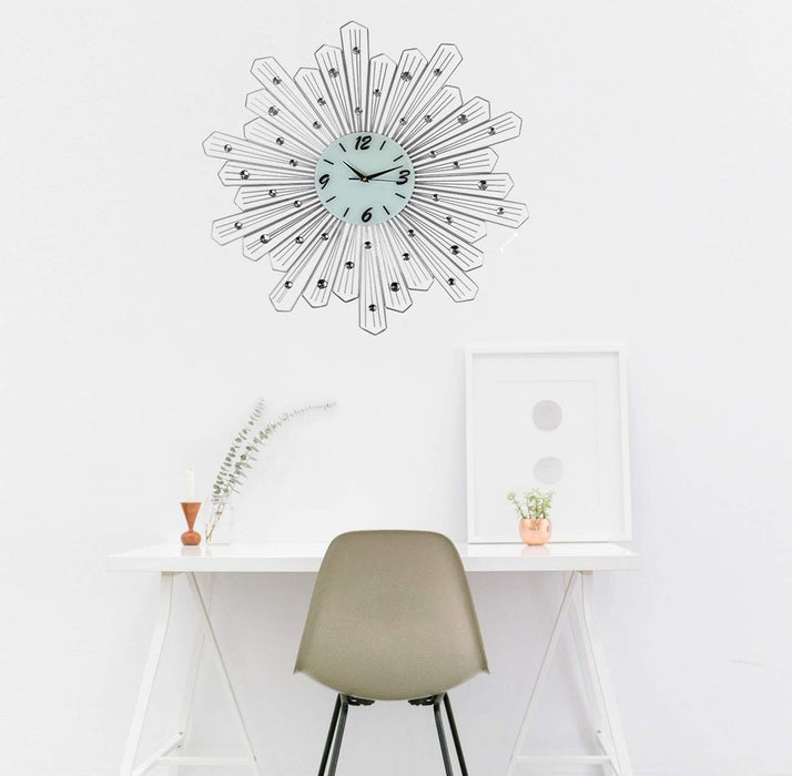 Decorative wall clock on a white wall above a desk with a chair.