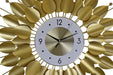 Decorative wall clock with gold leaf-like design on a white background