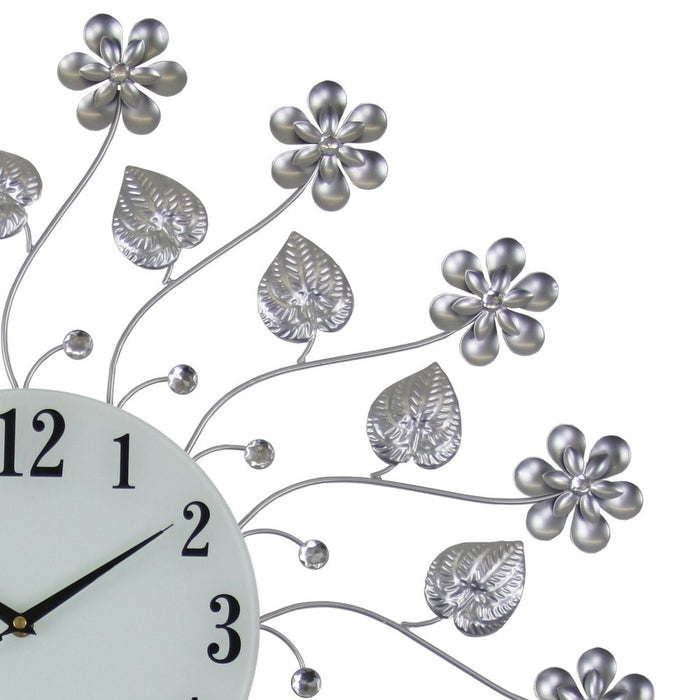 Decorative wall clock with floral and leaf designs on a white background