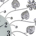 Decorative wall clock with floral and leaf designs on a white background