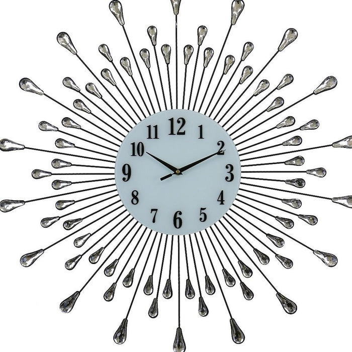 Decorative wall clock with sunburst design and teardrop accents on a white background