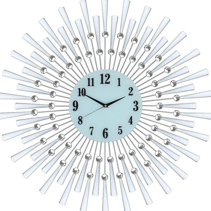Decorative wall clock with sunburst design and white arms on a light blue face.