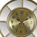 Gold clock with decorative design on a white background