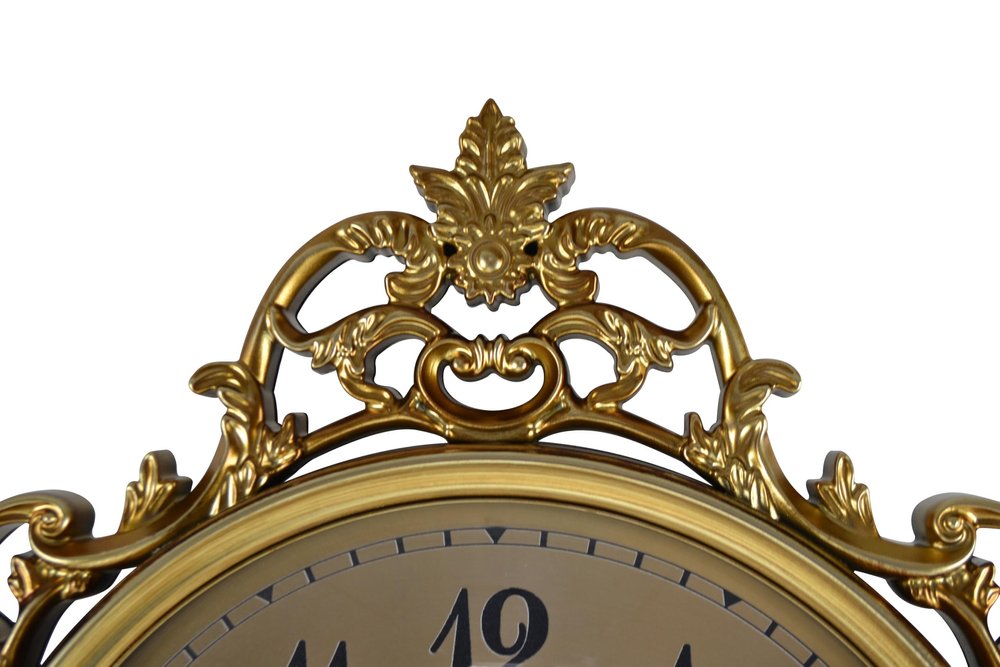 Decorative gold clock with intricate designs on a white background
