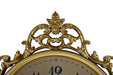 Decorative gold clock with intricate designs on a white background