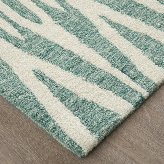 Teal and white striped rug on a wooden floor