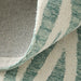 Close-up of a textured rug with green and beige stripes.