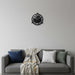 Wall clock on a gray wall above a gray sofa with cushions and a blanket.