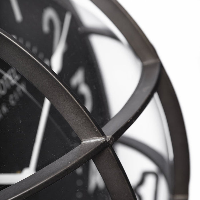 Close-up of a black metal clock with visible gears on a white background