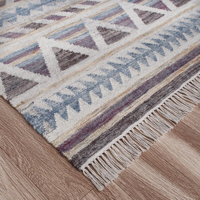 Patterned rug with fringes on a wooden floor
