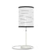 The "Random Fact" lamp features a text-patterned white cylindrical shade and a slim metallic base.